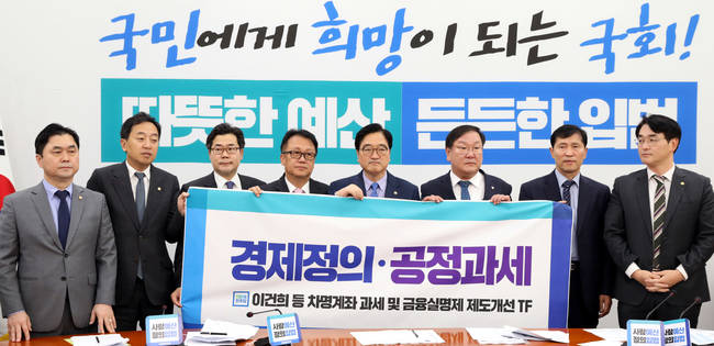 우원식(왼쪽 다섯번째) 더불어민주당 원내대표가 14일 오전 서울 영등포구 여의도 국회 더불어민주당 원내대표 회의실에서 진행된 원내대책회의에 앞서 이건희 등 차명계좌 과세 및 금융실명제 제도개선 TF팀과 경제정의 공정과세가 적힌 플래카드를 들고 포즈를 취하고 있다. 왼쪽부터 김종민, 금태섭, 박찬대, 민병두, 우원식, 김태년, 이학영, 박용진 의원.(뉴시스) 