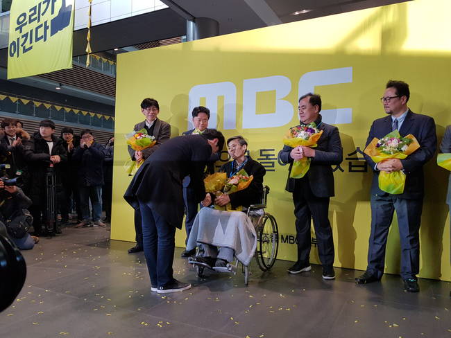 MBC 사원증을 전달받는 이용마 기자의 모습. 