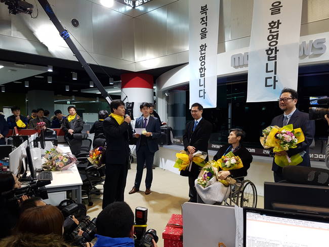 보도국 안에서 환영 행사를 받고 있는 복직 언론인들. 