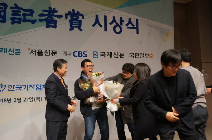 김성광 한겨레신문 사진기자가 상을 받고 동료들로부터 꽃다발을 받고 있다. 