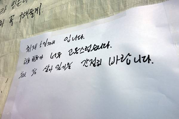 2014년 4월16일 세월호가 바다에 가라앉은 후로 4년이 흘렀다. 취재를 위해 팽목항과 진도체육관을 전전하던 기자들의 기억도 4년 전 것이 됐다. 기자들에게 세월호는 고통스러운 기억이다. 사진은 4년 전 진도 팽목항 민간 잠수부 구조대 천막 벽면에 생존을 기원하는 메시지가 가득한 가운데 한 기자가 남긴 안타까운 심정.  
