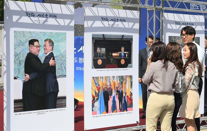  17일 서울 광화문 광장에서 열린 '평화, 새로운 미래-한반도 평화기원'을 주제로 한 보도사진전 개막식에서 관람객들이 사진을 보고 있다. (뉴시스) 