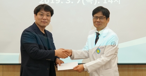 서울시 출입 기자단 간사를 맡고 있는 김승훈(왼쪽) 서울신문 기자가 지난 7일 서초구 서울특별시어린이병원에서 김재복 어린이병원장에게 후원금을 전달한 뒤 악수하고 있다. 