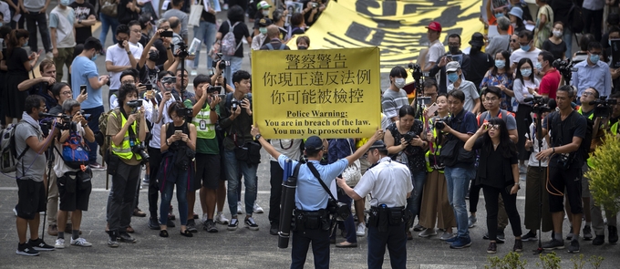 송환법 반대로 촉발된 홍콩 시위가 5개월 가까이 이어지면서 국제 사회의 관심이 높아지고 있다. 사진은 지난 18일(현지시간) 홍콩 경찰이 센트럴 구역에서 시위대를 향해 경고 손팻말을 들고 불법 집회에 대한 경고를 하고 있는 모습. /뉴시스 