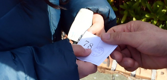 코로나19가 확산 중인 지난 2일 부산의 한 우체국 앞에서 시민들이 마스크를 구입하기 위해 대기 번호표를 받고 있다. 같은 날 KBS 취재진은 대구 지역 마스크 판매처에서 확진자를 마주치는 아찔한 경험을 하기도 했다. /뉴시스 