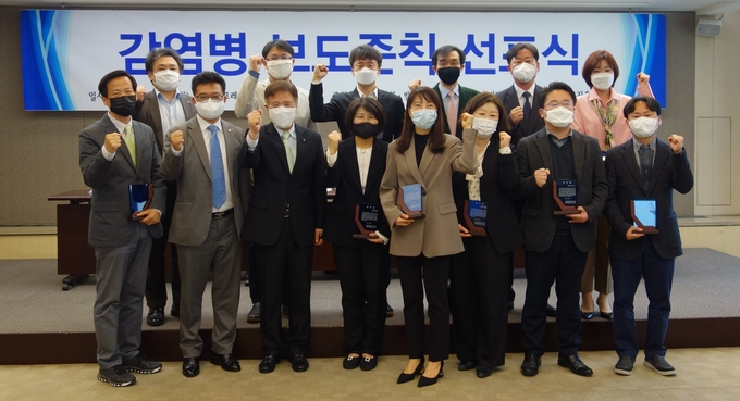 한국기자협회가 한국언론진흥재단의 후원을 받아 방송기자연합회, 한국과학기자협회와 공동으로 감염병 보도준칙을 제정하고 28일 공식 발표했다. 이날 서울 중구 한국프레스센터에서 열린 감염병 보도준칙 선포식에서 3단체장과 제정위원 등이 기념촬영을 하고 있다. 