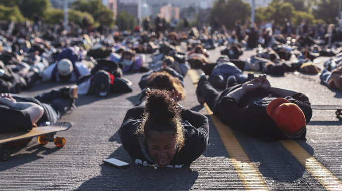 미국 오리건주 포틀랜드에서 지난 1일(현지시간) 조지 플로이드 사망 항의 시위 참석자들이 손을 뒤로 하고 땅에 엎드려 플로이드 사망 당시 모습을 재연하고 있다. /뉴시스 