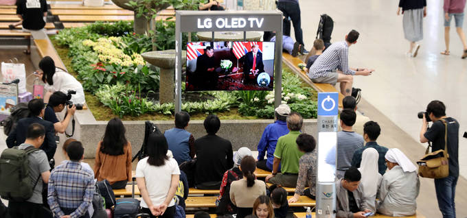 북미 정상회담이 개최된 지난해 6월12일 인천국제공항 제1여객터미널에서 시민들이 TV를 통해 북한 김정은 국무위원장과 미국 도널드 트럼프 대통령의 환담을 지켜보고 있다. /뉴시스 