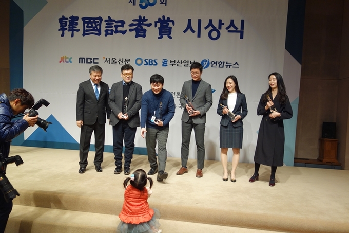 아빠를 축하하러 아장아장 단상을 오르는 아이의 귀여운 모습을 보며 서울신문 수상자들이 환하게 웃고 있다. 