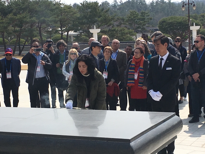 세계기자대회 참가자들이 5.18 추모탑 앞에서 분향하고 묵념하고 있다. 