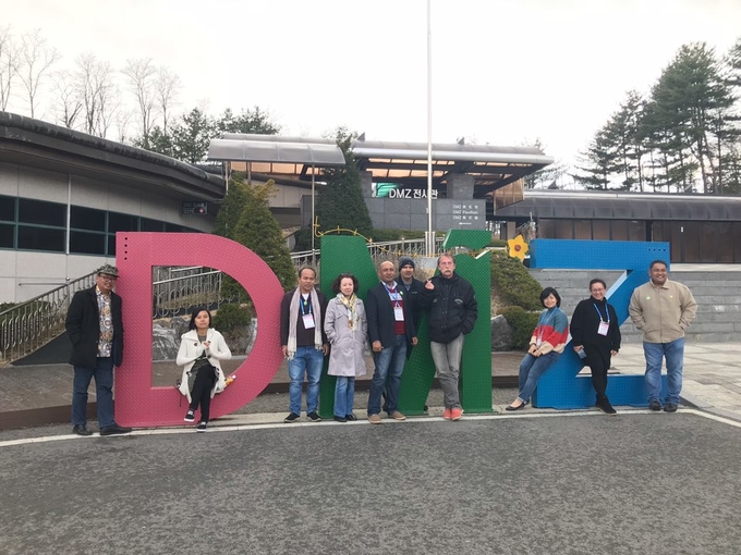 1박2일 DMZ 투어에 나선 외국기자들이 지난달 30일 판문점 남방 4km 지점에 위치한 제3땅굴을 둘러본 뒤 DMZ 로고를 배경으로 기념사진을 찍고 있다.   