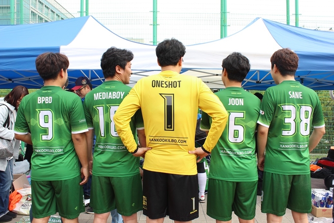 한국일보 선수단이 새로 바꾼 유니폼을 입고 포즈를 취했다. 등번호 위 선수이름 자리에 바이라인을 넣었다.  