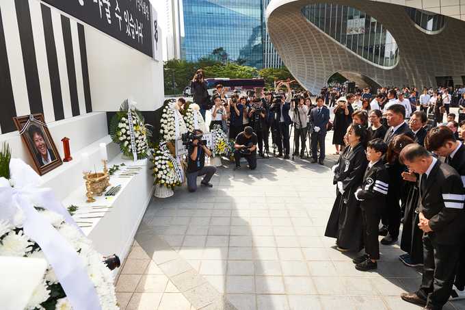 고 이용마 MBC기자의 영결식 '세상은 바꿀 수 있습니다' 시민사회장이 23일 서울 상암 MBC 앞 광장에서 열렸다. 식 막바지 유족이 헌화를 하고 있다. 배우자 김수영 씨와 아들 헌재, 경재. (언론노조 MBC본부) 