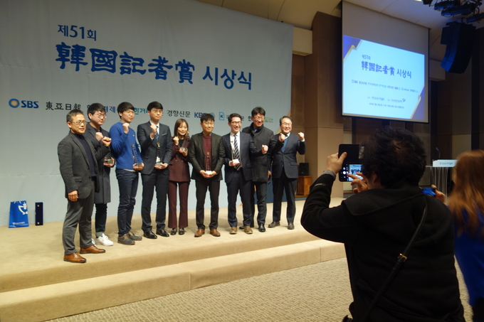 한국기자상 지역 기획보도부문을 수상한 국제신문 기자들의 모습을 이들의 가족들이 사진으로 남기고 있다. 
