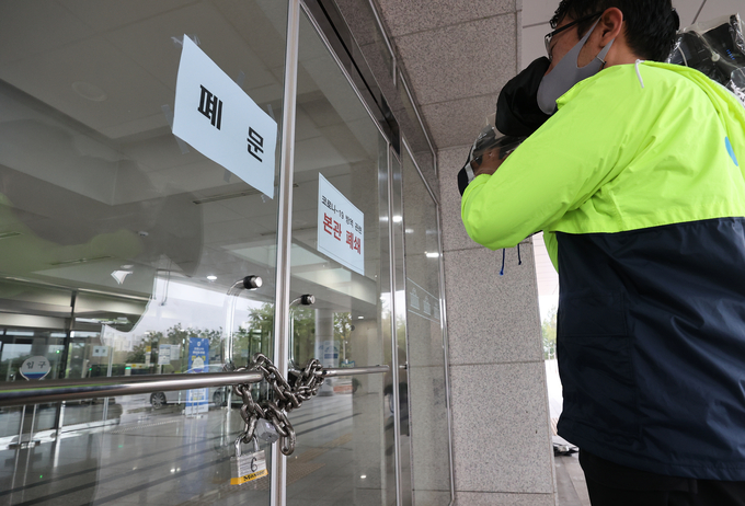 국회 출입기자의 신종 코로나바이러스 감염증(코로나19) 확진 판정으로 27일 오전 국회 본관이 폐쇄된 가운데 출입구 앞에서 한 취재진이 촬영하고 있다. /연합뉴스 