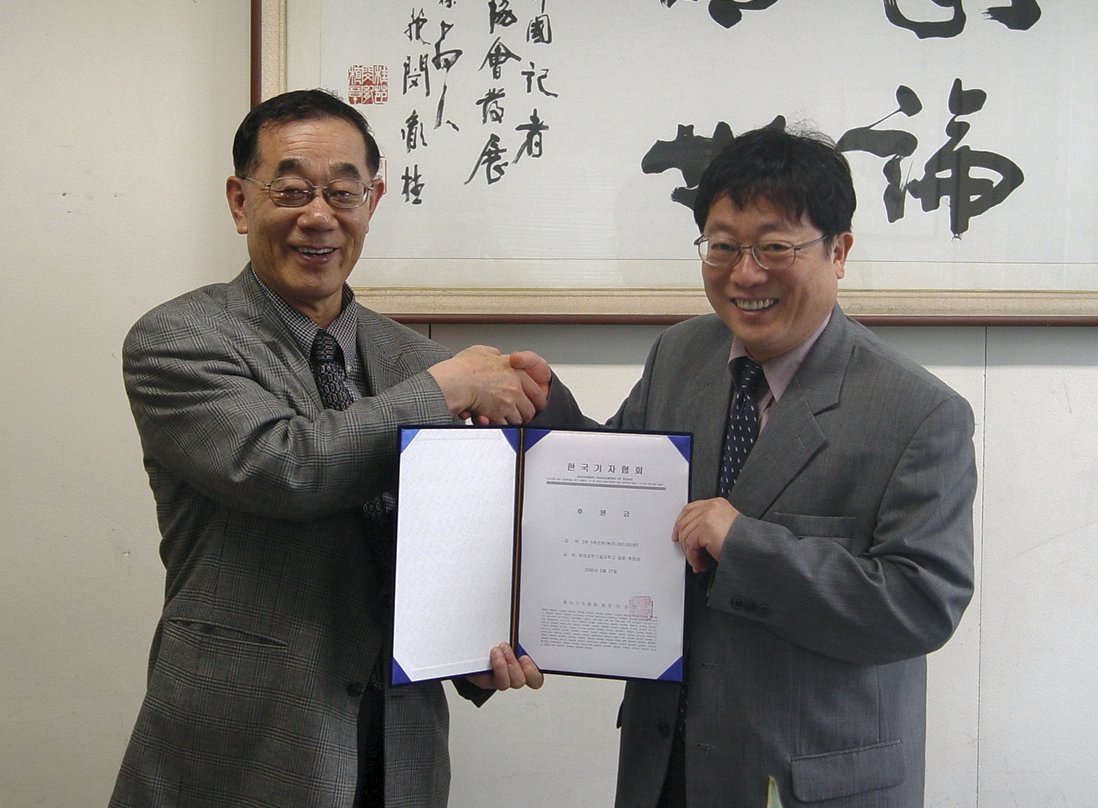 이상기 기자협회 회장이 김진경 연변과학기술대학 총장에게 평양과기대 설립 후원금을 전달하고 있다.