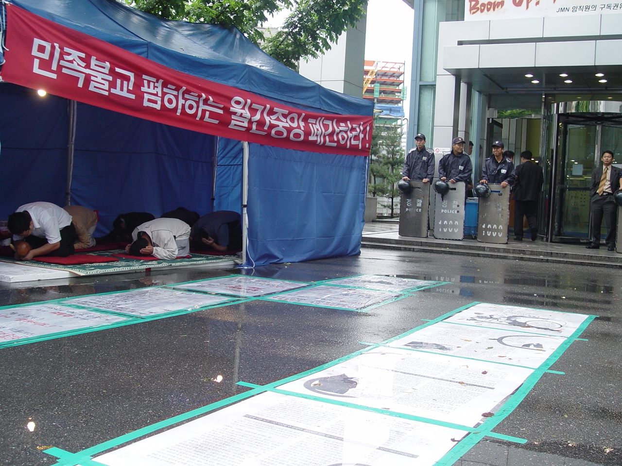 불교계 신도들이 지난 25일 월간중앙 앞에서 전경들이 지켜보고 있는 가운데 공양예불을 하고 있다.