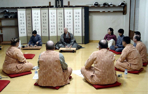 계룡산 무상사의 조실 대봉 스님과의 대화에서 미국기자협회 회원들이 푸른 눈의 스님인 대봉 스님의 불교 설법에 집중하고 있다.