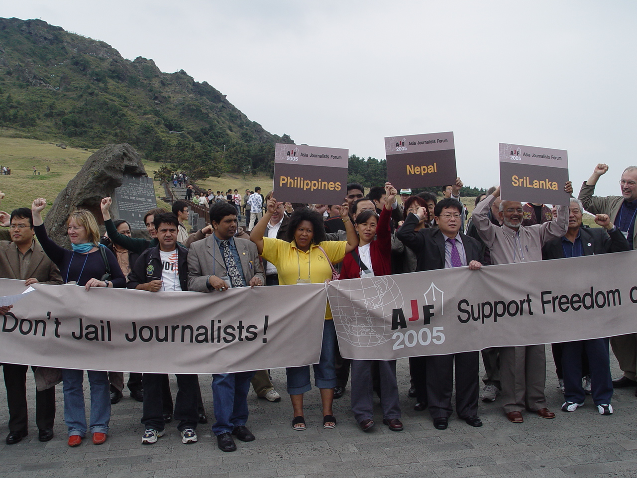 AFJ 참석자들이 제주 성산일출봉에서 언론탄압 중지를 요구하는 시위를 벌이고 있다.