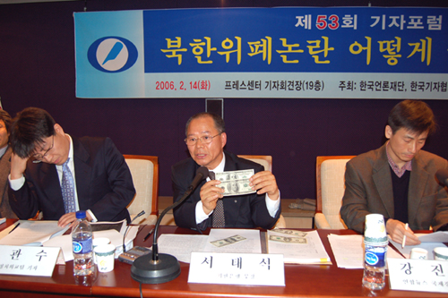 ‘제53회 기자포럼’의 두 번째 주제발표자로 나선 서영석 외환은행 부장(가운데)이 직접 위조달러지폐와 정상달러지폐 견본을 가지고 나와 진위 식별법에 대해 설명하고 있다.